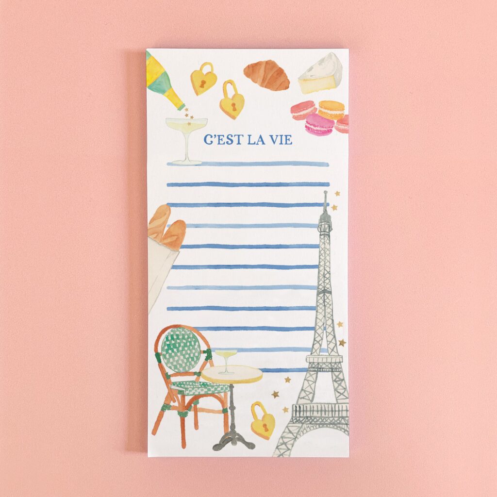 This whimsical 4" x 8" notepad is decorated with original watercolor paintings of Paris icons, including the Eiffel Tower, champagne, macarons, a bistro chair, and baguettes, plus the phrase “C’est la vie.” It’s perfect for grocery lists, to dos, or trip plans, and a sweet gift for any Francophile or traveler.
